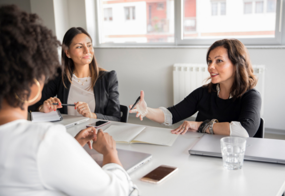 Drei Geschäftsfrauen diskutieren am Verhandlungstisch ©Getty Images Signature/M_a_y_a_ via Canva Pro
